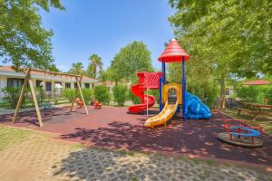 a playground with a slide and a swing set at Selene Resort - Amami Collection in Paestum