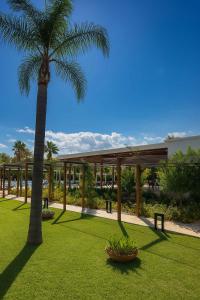 a palm tree in a yard with a building at Selene Resort - Amami Collection in Paestum