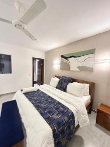 a bedroom with a large bed with a ceiling fan at Didas Villa Zanzibar in Zanzibar City