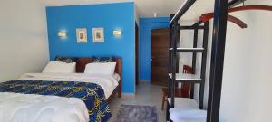 a bedroom with a bed and a blue wall at Didas Villa Zanzibar in Zanzibar City
