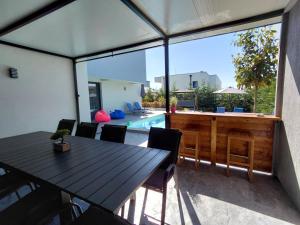 a patio with a table and chairs and a pool at Villa Cadaques, private pool with heating and salt water in Lozenets