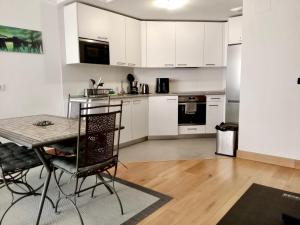 a kitchen with white cabinets and a table and chairs at RiverSide in Barakaldo