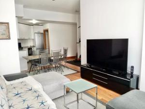 a living room with a couch and a flat screen tv at RiverSide in Barakaldo