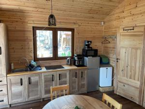 a kitchen with wooden walls and a table in a cabin at Domek z widokiem jeziora in Borsk