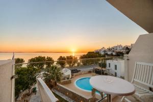 a balcony with a table and a view of the ocean at Aeolos Bay Tinos in Tinos