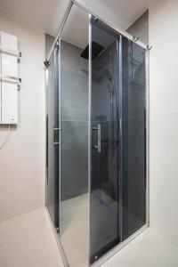 a shower stall with a glass door in a bathroom at New Modern Apartments with Private Parking in Leštane +86 photos