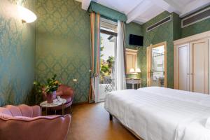 a bedroom with a bed and a table and chairs at Hotel Villa Delle Palme in Venice-Lido