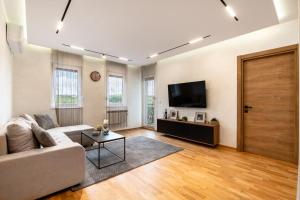 a living room with a couch and a tv at New Modern Apartments with Private Parking in Leštane