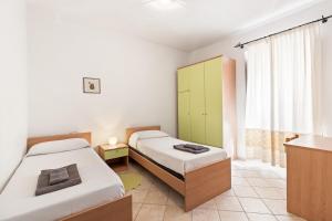 a bedroom with two beds and a window at Grande Casa Nel Villaggio in Scano Montiferro