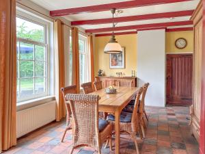 a dining room with a wooden table and chairs at Platschorre in Oudelande