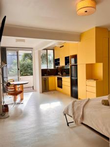 a kitchen with yellow cabinets and a bed in a room at Hello Bronte! in Sydney
