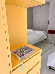 a bedroom with a yellow cabinet with a mirror at Hello Bronte! in Sydney