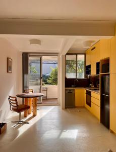 a kitchen with yellow cabinets and a table at Hello Bronte! in Sydney