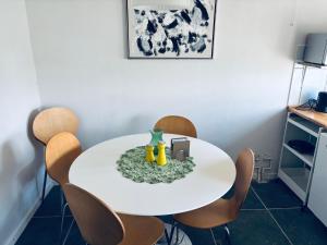 a white table with chairs and a vase on it at Søgården, 3080 Tikøb in Tikøb