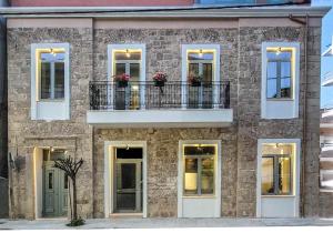 a brick building with a balcony and flowers on it at Evilion Suites in Xylokastro