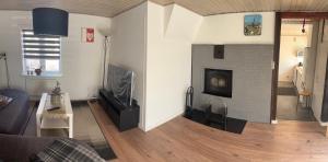 a living room with a fireplace and a tv at Søgården, 3080 Tikøb in Tikøb