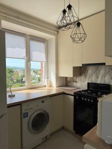a kitchen with a washing machine and a window at Панорама in Borysxaw