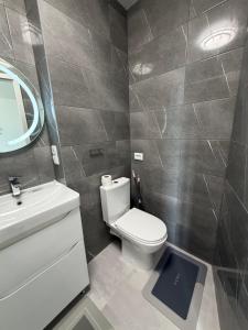 a bathroom with a toilet and a sink and a mirror at Панорама in Borysxaw