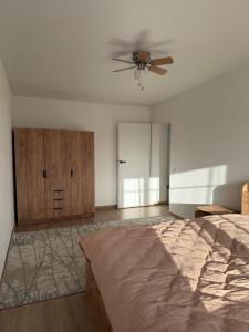 a bedroom with a bed and a ceiling fan at Панорама in Borysxaw