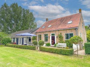 a brick house with an umbrella in the yard at Platschorre in Oudelande