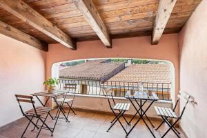 a balcony with tables and chairs and a large window at Grande Casa Nel Villaggio in Scano Montiferro +20 photos