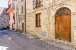 an old building with a wooden door on a street at Grande Casa Nel Villaggio in Scano Montiferro