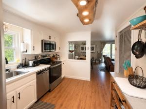 a kitchen with white cabinets and a counter top at Little Longbow Lakefront Chalet in Becket