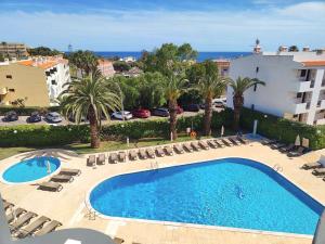 a large swimming pool with chairs and a building at Luna Clube Oceano in Albufeira
