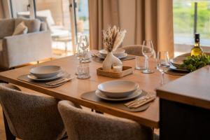 a wooden table with plates and glasses and a bottle of wine at LOFT 21 Rhön in Hofbieber
