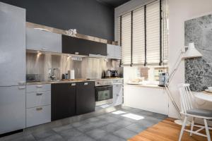 a kitchen with black and white appliances and a table at Chmielna, Sun&Snow in Warsaw