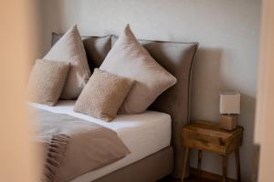 a bed with four pillows on it with a table at LOFT 21 Rhön in Hofbieber