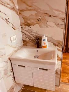 a bathroom with a sink and a marble wall at Shegani House in Lin +28 photos