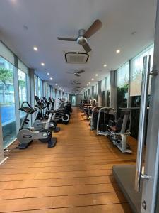 a gym with a row of treadmills and machines at VORTEX Suites KLCC Premium BY RRP in Kuala Lumpur