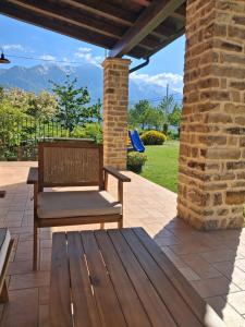 a wooden bench sitting on a patio with a brick wall at Agriturismo Bellavista in Arsita