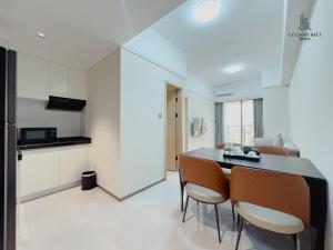 a kitchen and living room with a table and chairs at Le Conde Maison in Phnom Penh