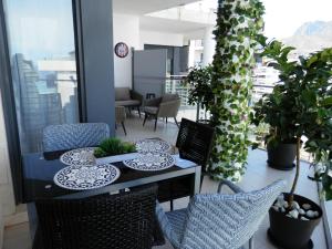a table and chairs on a balcony with plants at Aloha Benidorm in Cala de Finestrat