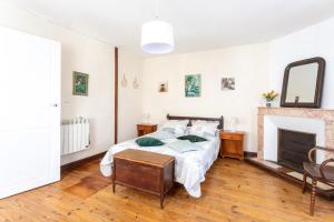 a bedroom with a bed and a fireplace at L'Authentique Maison Béarnaise in Lagor