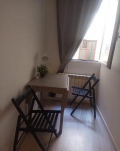 a table and two chairs in a room with a window at Matute Street, Private rooms in Madrid
