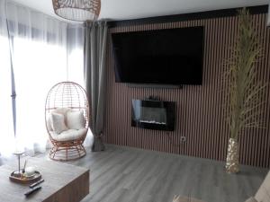 a living room with a tv and a chair at Aloha Benidorm in Cala de Finestrat
