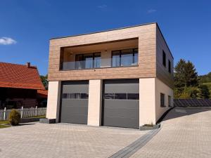 a house with two garage doors in a driveway at LOFT 21 Rhön in Hofbieber