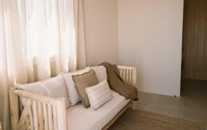 a white couch sitting in a room with a window at Apartamentos Eugenio by Formentera Passport in La Savina +56 photos