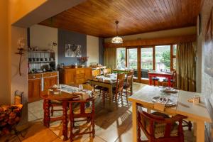 a kitchen with wooden ceilings and tables and chairs at Die Fonteine Country Guesthouse and Glamping in Oudtshoorn