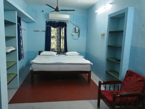 a bedroom with a bed and a window and a chair at Aiswarya illam in Chidambaram +39 photos
