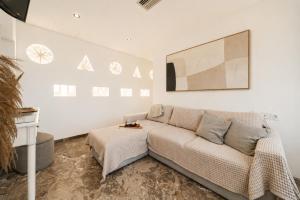 a living room with a couch and a painting on the wall at Aeolos Bay Tinos in Tinos