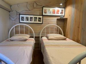 two beds in a room with wooden walls at DOMAINE St GEORGES in Mosset