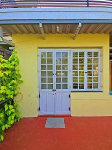 a yellow house with a garage with a door at Manasthala Brindavan in Mysore