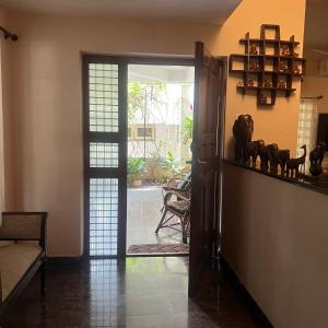 a living room with a door open to a patio at Manasthala Brindavan in Mysore