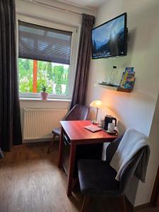 a room with a desk and a chair and a window at Susann Vendégház in Szigetmonostor