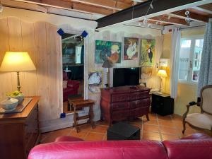 a living room with a red couch and a desk at DOMAINE St GEORGES in Mosset