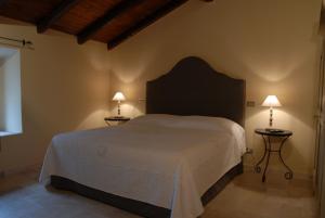 a bedroom with a large bed with two lamps on tables at Tenuta Folesano Wine Estate 13th century in Marzabotto